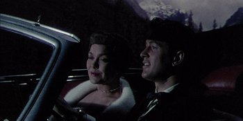 Movie still from “Magnificent Obsession” (1954), directed by Douglas Sirk – A man and a woman sitting in the back of a car; Medium shot, Low angle