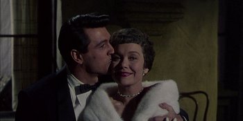 Movie still from “Magnificent Obsession” (1954), directed by Douglas Sirk – A man kissing a woman's cheek in front of a wall; Close Up shot, Low angle