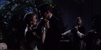 Movie still from “Magnificent Obsession” (1954), directed by Douglas Sirk – A man and a woman are holding their ties; Medium shot, Low angle