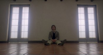 Movie still from “Making Love” (1982), directed by Arthur Hiller – A man sitting on the ground in a room; Wide shot, Low angle