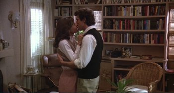 Movie still from “Making Love” (1982), directed by Arthur Hiller – A man and a woman kissing in a living room; Medium shot, Over the shoulder angle