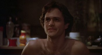 Movie still from “Making Love” (1982), directed by Arthur Hiller – A man with a beard is smiling for the camera; Close Up shot, Low angle