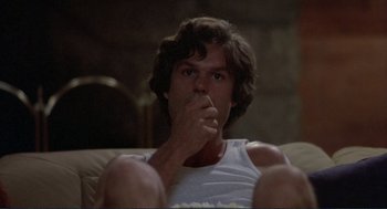 Movie still from “Making Love” (1982), directed by Arthur Hiller – A man sitting on top of a couch with his hand to his mouth; Close Up shot, Low angle
