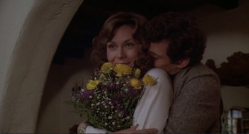 Movie still from “Making Love” (1982), directed by Arthur Hiller – A man and a woman holding a bouquet of flowers; Close Up shot, Over the shoulder angle