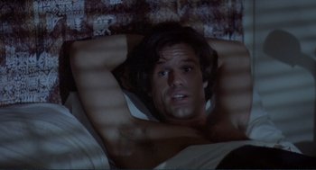 Movie still from “Making Love” (1982), directed by Arthur Hiller – A man laying in a bed with his hands behind his head; Close Up shot, Overhead angle