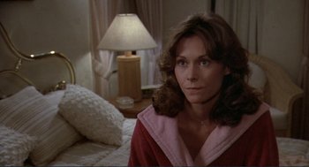 Movie still from “Making Love” (1982), directed by Arthur Hiller – A woman sitting on a bed in a room; Close Up shot, High angle