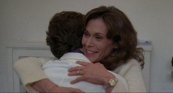 Movie still from “Making Love” (1982), directed by Arthur Hiller – A woman is hugging a man with a ring on his finger; Close Up shot, Over the shoulder angle