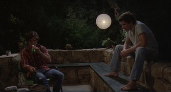 Movie still from “Making Love” (1982), directed by Arthur Hiller – Two men sitting on a bench in the dark; Wide shot, High angle