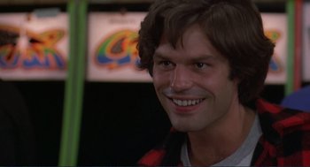 Movie still from “Making Love” (1982), directed by Arthur Hiller – A person with a smile on their face; Close Up shot, Over the shoulder angle