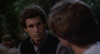 Movie still from “Making Love” (1982), directed by Arthur Hiller – A man in a black vest is talking to another man; Close Up shot, Over the shoulder angle