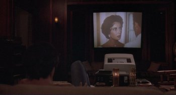 Movie still from “Making Love” (1982), directed by Arthur Hiller – A person sitting in front of a television; Medium shot, High angle