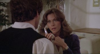 Movie still from “Making Love” (1982), directed by Arthur Hiller – A woman is talking on a phone while a man looks on; Close Up shot, Over the shoulder angle