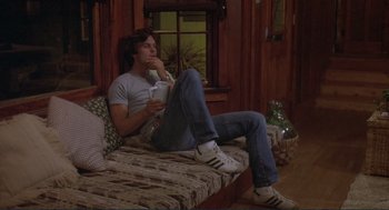 Movie still from “Making Love” (1982), directed by Arthur Hiller – A man sitting on a couch holding a wii controller; Medium shot, Low angle