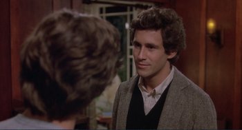 Movie still from “Making Love” (1982), directed by Arthur Hiller – A man wearing a suit and tie talking to a woman; Close Up shot, Over the shoulder angle