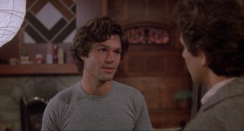 Movie still from “Making Love” (1982), directed by Arthur Hiller – A young man in a grey shirt is talking to a younger man; Close Up shot, Over the shoulder angle