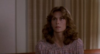 Movie still from “Making Love” (1982), directed by Arthur Hiller – A woman with long hair sitting in front of a curtain; Close Up shot, Over the shoulder angle