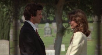 Movie still from “Making Love” (1982), directed by Arthur Hiller – A man and a woman standing next to each other in a cemetery; Medium shot, Over the shoulder angle