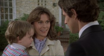 Movie still from “Making Love” (1982), directed by Arthur Hiller – A woman and two young boys are talking to each other; Close Up shot, Over the shoulder angle