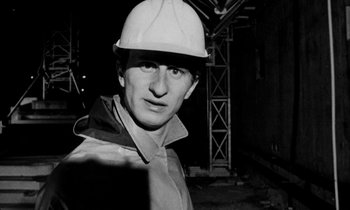 Movie still from “Man Bites Dog” (1992), directed by Benoît Poelvoorde – Black and white photograph of a man wearing a hard hat; Close Up shot, Low angle
