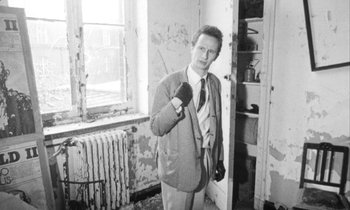 Movie still from “Man Bites Dog” (1992), directed by Benoît Poelvoorde – A black and white photo of a man holding a brush; Medium shot, Low angle