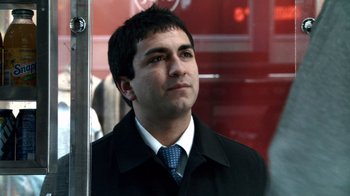 Movie still from “Man Push Cart” (2005), directed by Ramin Bahrani – A man wearing a black jacket and a blue tie; Close Up shot, Low angle