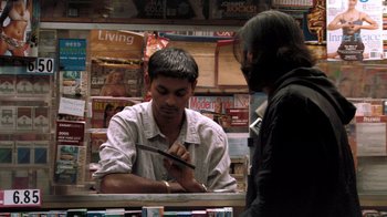 Movie still from “Man Push Cart” (2005), directed by Ramin Bahrani – A man is writing on a piece of paper in front of another man; Medium shot, Over the shoulder angle