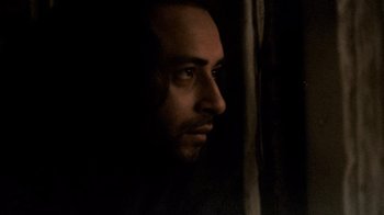 Movie still from “Man Push Cart” (2005), directed by Ramin Bahrani – A person's face in the dark; Close Up shot, Low angle