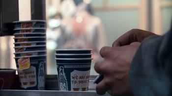 Movie still from “Man Push Cart” (2005), directed by Ramin Bahrani – A person is holding a cigarette in their hand and a cup of coffee in their other hand; Extreme Close Up shot, Low angle