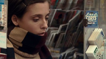 Movie still from “Man Push Cart” (2005), directed by Ramin Bahrani – A young woman wearing a scarf and a sweater; Close Up shot, Over the shoulder angle