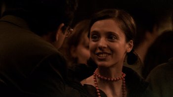 Movie still from “Man Push Cart” (2005), directed by Ramin Bahrani – A woman wearing a red necklace smiling for the camera; Close Up shot, Over the shoulder angle