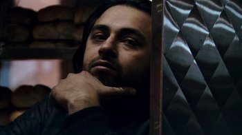 Movie still from “Man Push Cart” (2005), directed by Ramin Bahrani – A person leaning against a wall; Close Up shot, Low angle