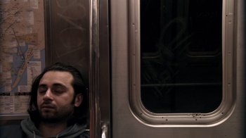Movie still from “Man Push Cart” (2005), directed by Ramin Bahrani – A man sleeping on a subway train in the middle of the day; Close Up shot, Overhead angle