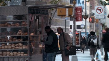Movie still from “Man Push Cart” (2005), directed by Ramin Bahrani – Two men standing in front of a store on a city street; Wide shot, Over the shoulder angle