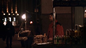 Movie still from “Man Push Cart” (2005), directed by Ramin Bahrani – A man standing in front of a hot dog stand; Wide shot, High angle