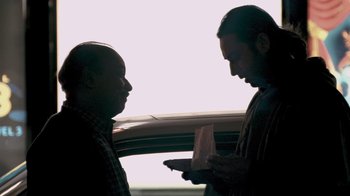 Movie still from “Man Push Cart” (2005), directed by Ramin Bahrani – Two men standing next to each other in front of a window; Medium shot, Over the shoulder angle