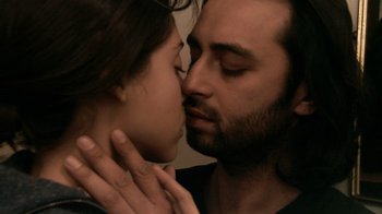 Movie still from “Man Push Cart” (2005), directed by Ramin Bahrani – A man and a woman are kissing in a room; Close Up shot, Over the shoulder angle