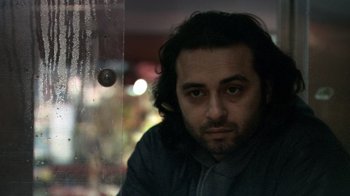 Movie still from “Man Push Cart” (2005), directed by Ramin Bahrani – A person with long dark hair; Close Up shot, Low angle