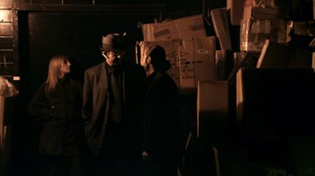 Movie still from “Man Push Cart” (2005), directed by Ramin Bahrani – A man in a suit and hat standing next to another man in a hat; Medium shot, Low angle