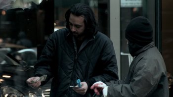 Movie still from “Man Push Cart” (2005), directed by Ramin Bahrani – A man in a black jacket is looking at his cell phone; Medium shot, High angle