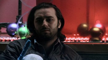 Movie still from “Man Push Cart” (2005), directed by Ramin Bahrani – A person with long black hair; Close Up shot, Low angle
