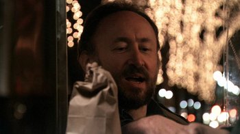 Movie still from “Man Push Cart” (2005), directed by Ramin Bahrani – A man with a beard is holding a paper bag; Close Up shot, Low angle