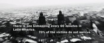 Movie still from “Man on Fire” (2004), directed by Tony Scott – A black and white photo of a city skyline with a quote; Wide shot, High angle