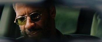 Movie still from “Man on Fire” (2004), directed by Tony Scott – A person wearing sunglasses; Close Up shot, Over the shoulder angle