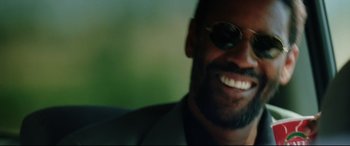 Movie still from “Man on Fire” (2004), directed by Tony Scott – A person wearing sunglasses and smiling; Close Up shot, Low angle