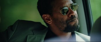 Movie still from “Man on Fire” (2004), directed by Tony Scott – A person wearing sunglasses and a jacket; Close Up shot, Low angle