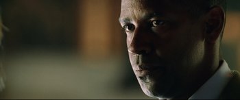 Movie still from “Man on Fire” (2004), directed by Tony Scott – A man's face in a dark room; Close Up shot, Low angle
