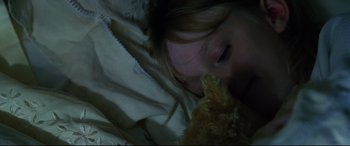 Movie still from “Man on Fire” (2004), directed by Tony Scott – A little girl laying in bed with a teddy bear; Close Up shot, Overhead angle