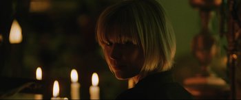 Movie still from “Man on Fire” (2004), directed by Tony Scott – A woman with blonde hair is standing in front of candles; Close Up shot, Over the shoulder angle