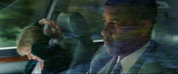 Movie still from “Man on Fire” (2004), directed by Tony Scott – A man sitting in the driver's seat of a car; Close Up shot, Low angle