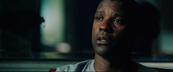 Movie still from “Man on Fire” (2004), directed by Tony Scott – A person looking at the camera; Close Up shot, Low angle